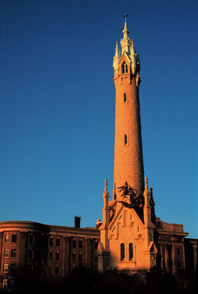 Photograph of the North Point Water Tower in 1985 with a temporary dragon sculpture mounted on it.  