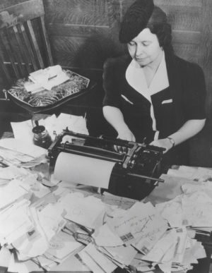 Photograph of Ione Quinby Griggs working at a typewriter during World War II. 