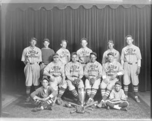 Group photograph of the 1929 Lincoln Avenue Merchants baseball team posed with a trophy. 