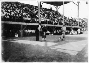 Photograph of spectators watching a baseball game between the Kosciuszko Reds and the Peters Union Giants in 1912.