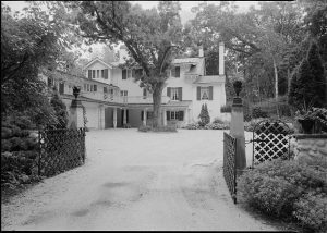 Photograph of the Ten Chimneys property looking south through the driveway gate.