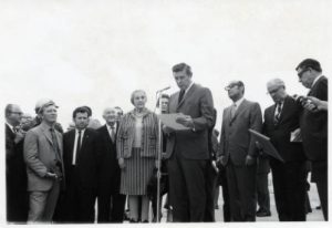 Photograph of Golda Meir and Mayor Henry Maier taken in 1969 on Meir's diplomatic visit to Milwaukee. Meir is seen just to the left of Maier, who is standing at the microphone. 