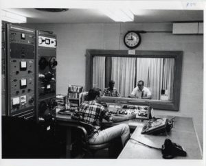 Photograph showcasing the radio booth and production of a WUWM broadcast, taken between 1978 and 1980. 