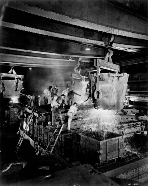 A group of male employees work with heavy industrial equipment inside Falk Corporation in 1963. 