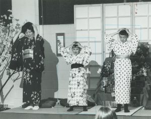 Two young boys and their mother perform a traditional Japanese song for school children gathered at the International Institute for Ethnic Spring Festival. The Japanese American Civic League was a member organization of the International Institute. 