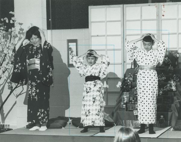 Two young boys and their mother perform a traditional Japanese song for school children gathered at the International Institute for Ethnic Spring Festival. The Japanese American Civic League was a member organization of the International Institute. 