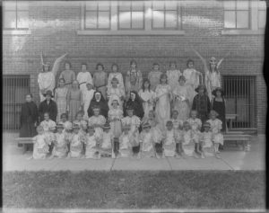 A group portrait of children in costumes and nuns at the St. Joseph Orphanage in 1921. 