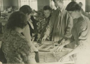 Individuals learn to weave as part of the Works Progress Administration's Milwaukee Handicraft Project, which provided light manufacturing work for unskilled workers.