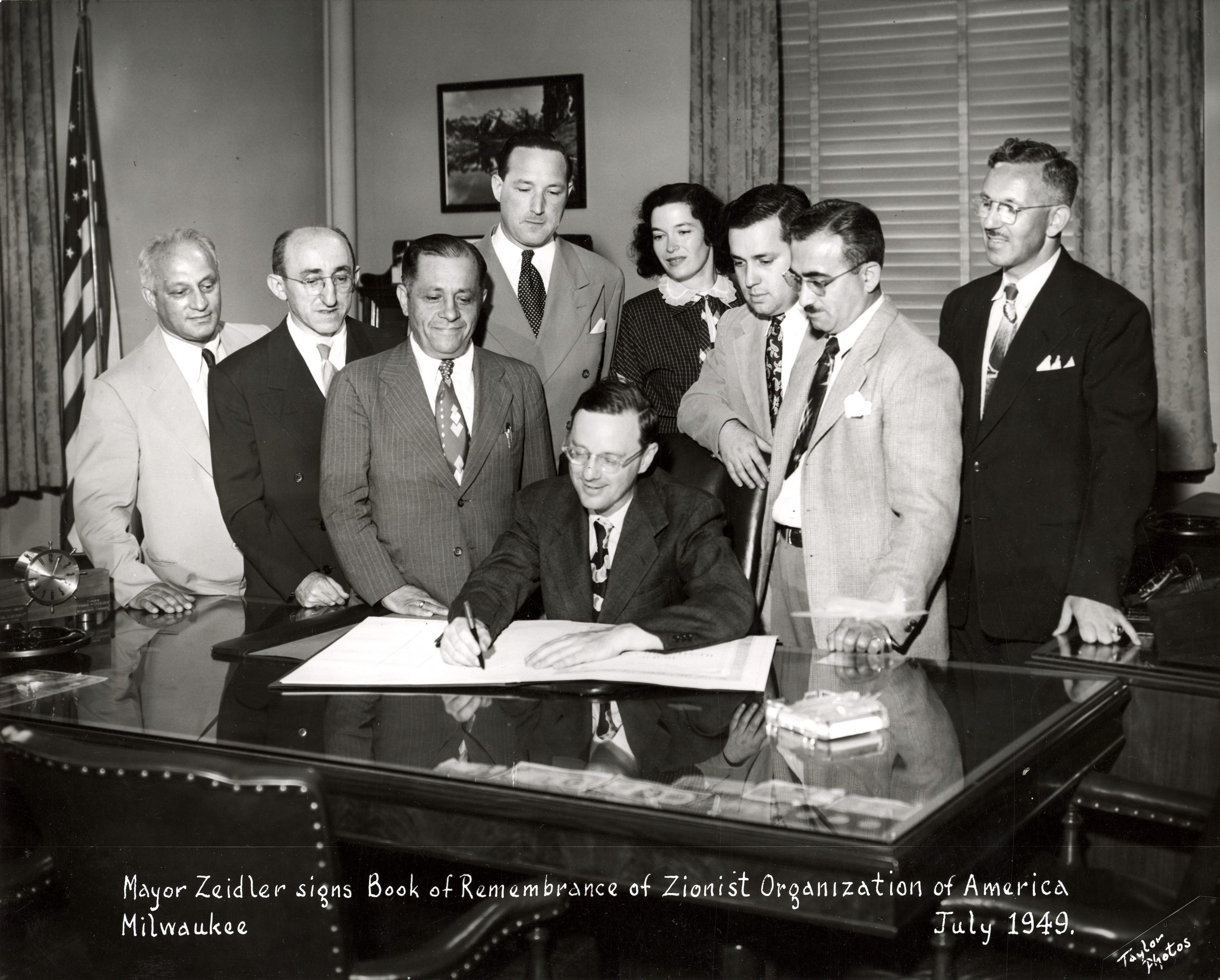 Mayor Frank Zeidler signs a Book of Remembrance while members of the Zionist Organization of America look on in this 1949 photograph.