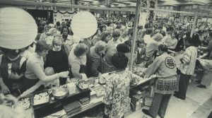 People stand in line to try ethnic foods at the Holiday Folk Fair, served by people in traditional dress, in 1982.