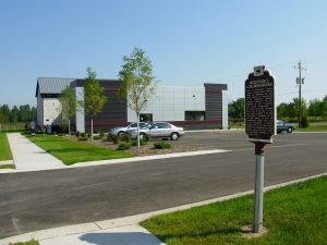 A historical landmark sign marks the importance of Luxembourger settlement. The Luxembourg American Cultural Center stands in the background. 