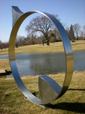 Photograph of Bernard Kirschenbaum's 1976 sculpture titled "Way Four." It is part of the Lynden Sculpture Garden; other artworks can be seen in the background. 