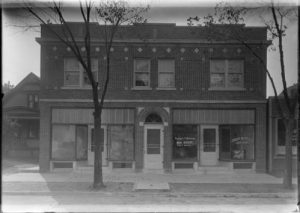 This photograph shows the offices of Valerian M. Popowski Real Estate and the Cudahy Savings and Loan Association, as well as a vacant storefront in the 1920s.