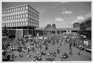 Students gather on UWM's plaza for a party in September 1985. Bolton Hall is on the left, Golda Meir Library center background, and the Fine Arts Center is on the right. 