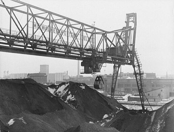 Photograph featuring a bridge at the Seventeenth Street dock of the Milwaukee Western Fuel Company in 1942. The bridge is used for unloading coal from ships and loading it into cars and hoppers. 