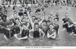 A large group of people are pictured swimming in the Milwaukee River as part of Whittaker's Swimming School.